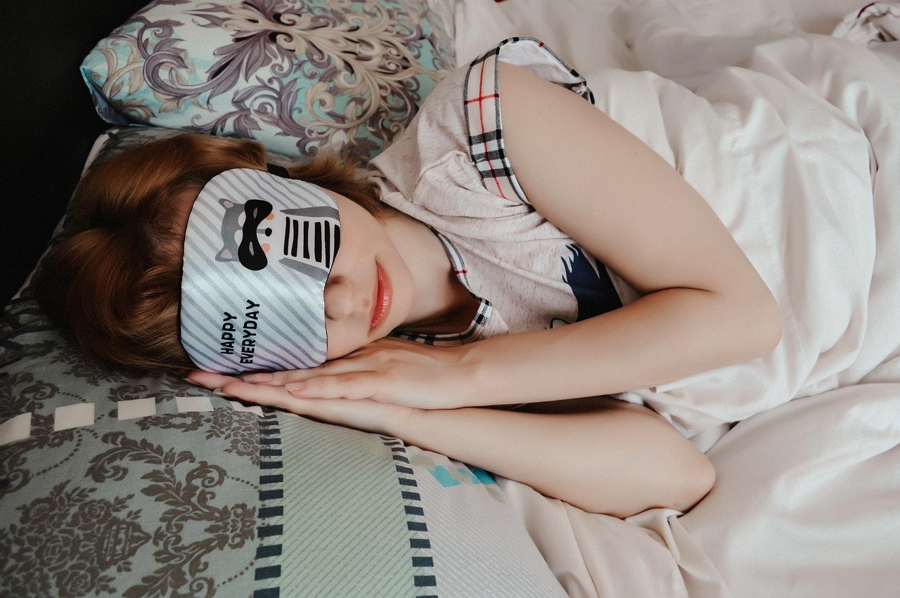femme dormant dans son lit avec masque de sommeile