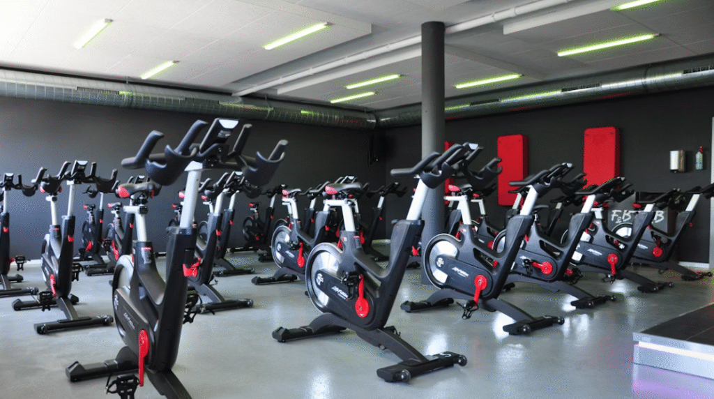 salle de fitness avec beaucoup de vélos d'appartement
