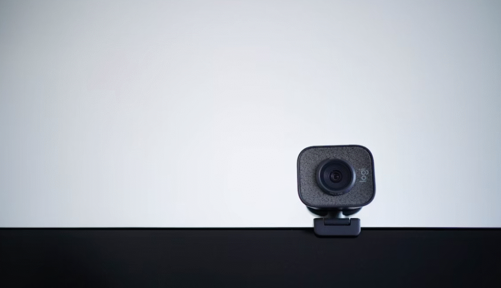 petite webcam logitech noire installée au dessus d'un écran PC noir