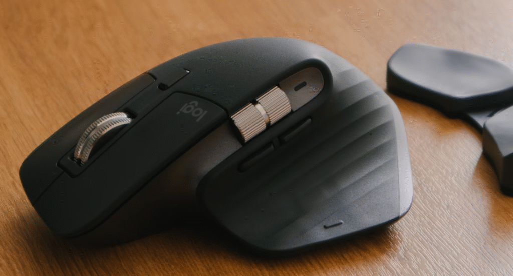 souris ergonomique noire posée sur un bureau en bois
